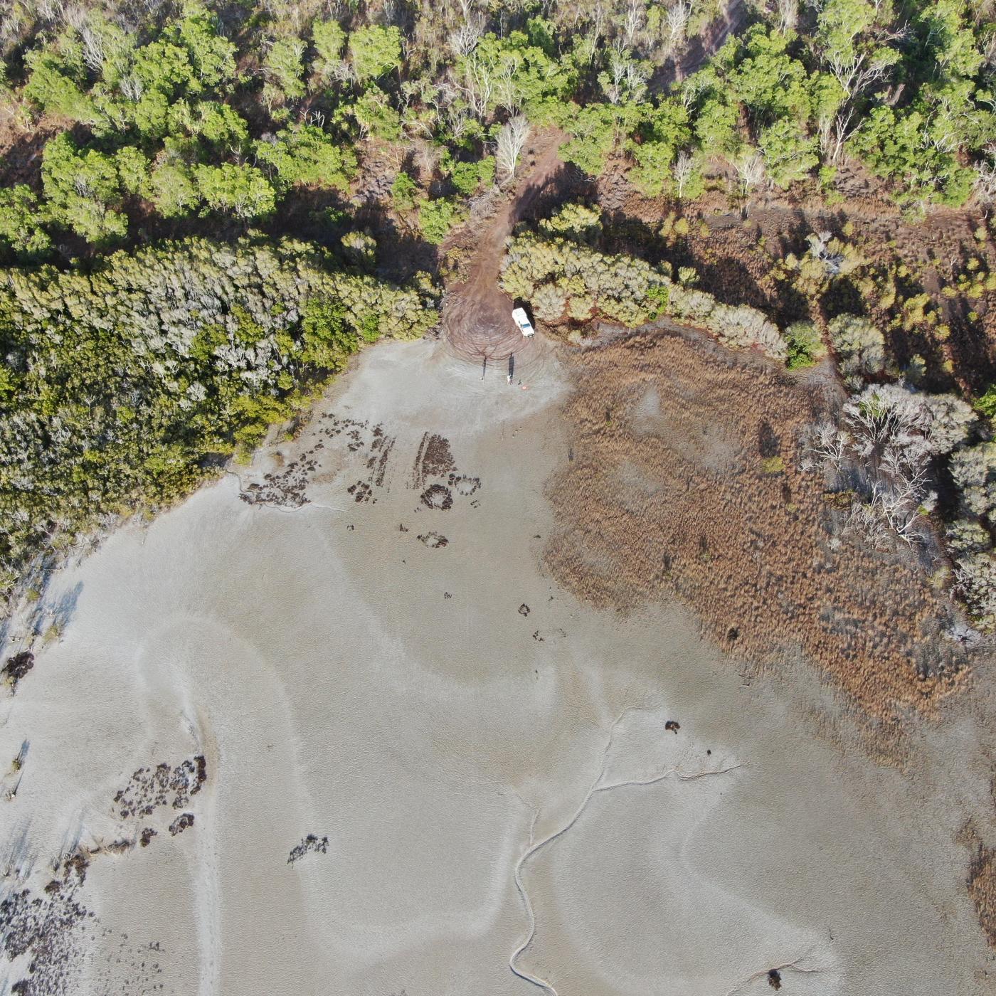 Aerial photo of car on edge of mud flat