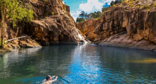 Small falls and waterhole with man swimming