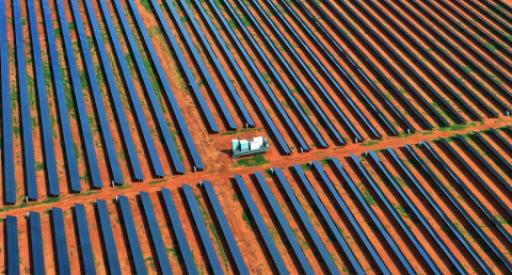 Aerial view of rows of solar panels set on red dirt